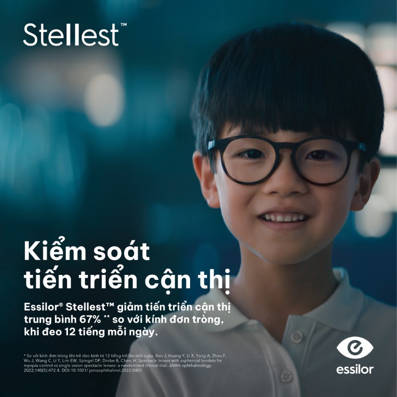 Trẻ em đeo kính Stellest Essilor kiểm soát tiến triển cận thị, nền xanh hiện logo Essilor